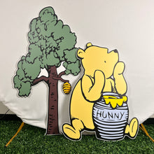 Load image into Gallery viewer, Winnie The Pooh Prop Set - Baby Shower Props - A little Honey is on the way - Winne the Pooh Cutout - Pooh with honey Prop - Lifesize Winnie the Pooh Cutout - Foamboard Cutouts - Coroplast Cutouts - Pooh and Tree Cutouts - Set of 2 Party Standees